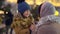 Cute excited son talking with mother on city square decorated for Christmas. Portrait of positive happy Middle Eastern