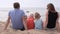 Cute family with children looks at the sea