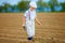 Cute farmer boy walking the arable field