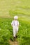 Cute farmer boy walking through the potato rows