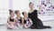 Cute Female ballet teacher is taking selfie with her little student with smartphone and posing looking at camera while