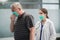 Cute female doctor listens to the lungs of her elderly patient, he is sick and coughs