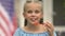 Cute female kid blowing soap bubbles smiling on camera, childhood happiness