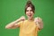 Cute female rebel in yellow t-shirt with gap teeth pulling fist towards camera as if showing fighting skills yelling