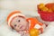Cute few days newborn baby with funny curious face dressed in a