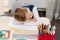 A cute first grader boy in a school uniform at home during a pandemic fell asleep doing homework at a desk with books and pencils