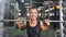 Cute fitness woman lifting heavy barbell