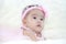 Cute five months asian baby in pink dress., on soft carpe