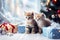 Cute fluffy kittens with gift boxes and a Christmas tree on a blurred background. Adorable little tabby cats. Cozy home
