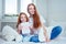 Cute foxy hair little girl giving the drawing on paper to redhaired ginger mother at bedroom