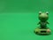 Cute frog toy on a green background. Free space for text