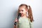 Cute fun kid girl singing song in microphone on blue background.