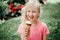 Cute funny adorable girl with dirty nose and milk moustaches eating licking ice cream from waffle cone. Child eating tasty sweet