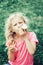 Cute funny adorable girl with long blonde messy hair eating licking ice cream from waffle cone. Child eating tasty sweet cold