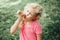 Cute funny adorable girl with long messy blonde hair eating licking ice cream from waffle cone. Child eating tasty sweet cold