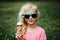 Cute funny adorable girl in sunglasses with dirty nose and moustaches eating ice cream from waffle cone. Happy cool hipster child
