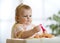 Cute funny baby girl eating spaghetti at home