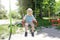 Cute funny blond little young toddler kid child boy sitting and riding on swing in playground in park.Children physical,emotional