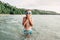 Cute funny Caucasian boy swimming in lake river with underwater goggles. Child diving in water