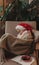 Cute funny girl in a Santa Claus hat, sleeping in a chair at home. Festive New Year food concept
