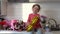 Cute funny little girl holding golden ballon 8 eight sitting on kitchen table with bouquets of spring flowers , greeting mother or