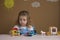 Cute funny preschooler little girl playing with construction toy blocks building a tower in kindergarten room.