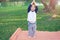 Cute funny smiling Asian 18 months / 1 year old toddler baby boy child try to practices yoga in Tree Pose and meditating outdoors