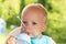 Cute funny toddler drinking water. One year baby boy makes a water stream with his mouth