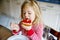 Cute funny toddler girl eats sweet bun for breakfast. Happy child eating bread roll with strawberry jam. Health food for