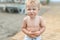 Cute funny upset caucasian 2 year old toddler boy standing abandoned alone at beach summer day. Offended scared child