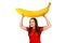 Cute funny young girl holds over herself huge banana, isolated on a white background