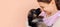 Cute German shepherd puppy kissing woman`s nose