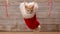 Cute ginger cat sitting in a santa hat hanging on drying line