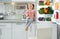 Cute girl with apple sitting near refrigerator