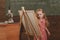 Cute girl artist painting picture on canvas on easel. Little child learn drawing on studio easel, vintage filter