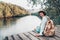 Cute girl backpacking and sitting on the wood plank resting