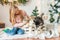 Cute girl with blond long hair plays with small Malamute puppies at home