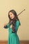 Cute girl in a blue dress with a violin. toned. vertical photo