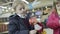 Cute girl and boy choosing toys for decorate Christmas tree at shopping centre