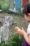 Cute girl with braids feeding bunnies on a farm