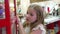 Cute girl carefully with interest examines toys in store for harry potter fans