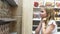 Cute girl carefully with interest examines toys in store for harry potter fans