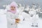 Cute girl child feeds swan. Baby with bread in hand at swans lake in winter