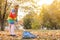 Cute girl cleaning fallen leaves with rake