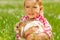 Cute girl cuddling rabbit in green field