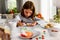 Cute girl decorating cookies for Halloween