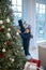 Cute girl decorating new year tree with her robot friend