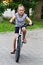 Cute girl driving bicycle in summer