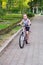 Cute girl driving bicycle in summer