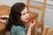 cute girl eating strawberries in the kitchen while chatting with grandma